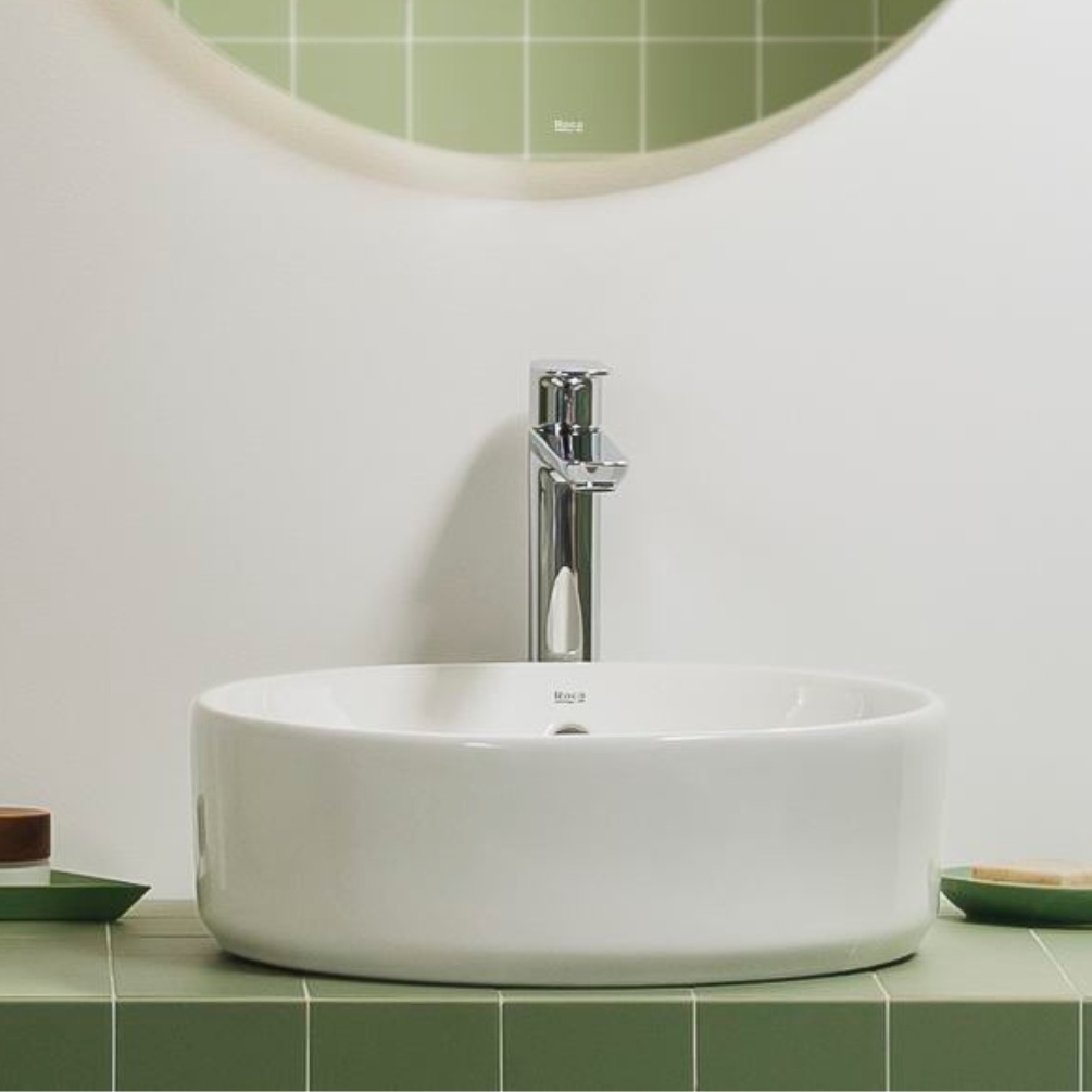 Lifestyle image of the Roca The Gap 390mm Round Countertop Basin mounted on a green tiled countertop